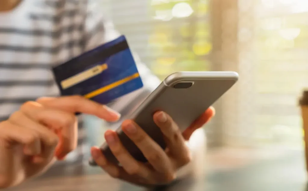 スマートフォンで海外発行のクレジットカードによるオンライン決済を確認する様子