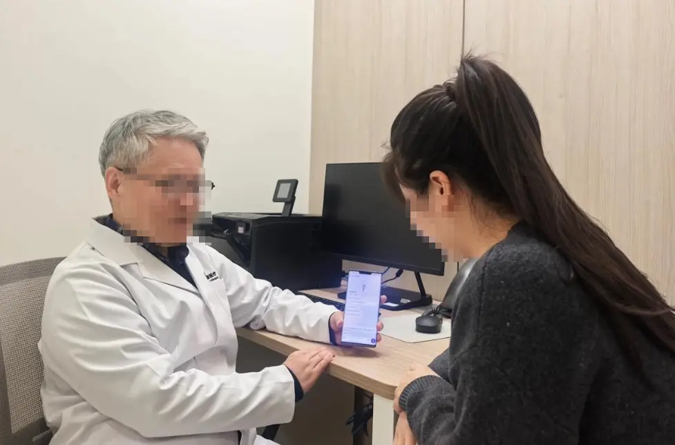 韓国の皮膚科でスマートフォンの翻訳画面を見せながら相談する様子。